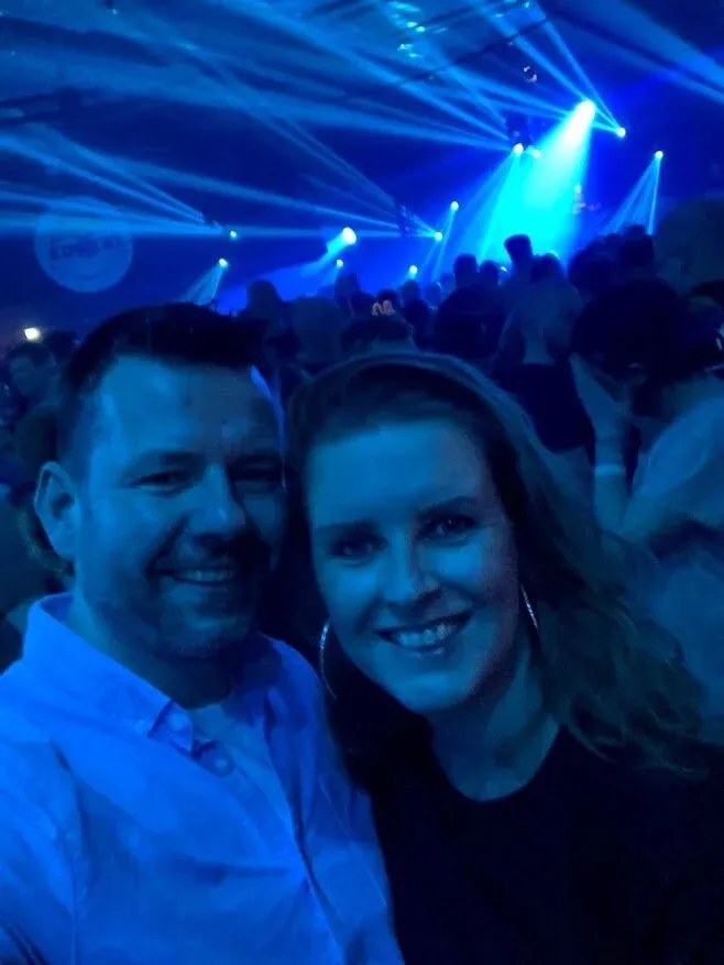 iPhone-selfie van een stel voor blauwe lampen, het gezicht onscherp
