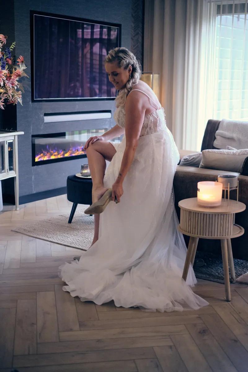 Tamara trekt haar schoenen aan in de woonkamer