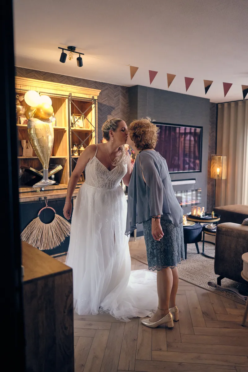 Tamara in haar trouwjurk, met de laatste hulp in de woonkamer