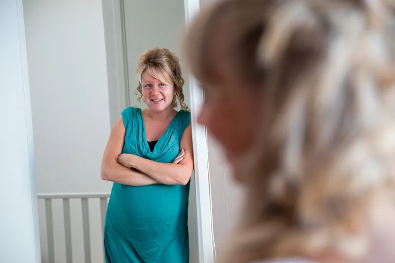 Een gast kijkt lachend toe in de gang