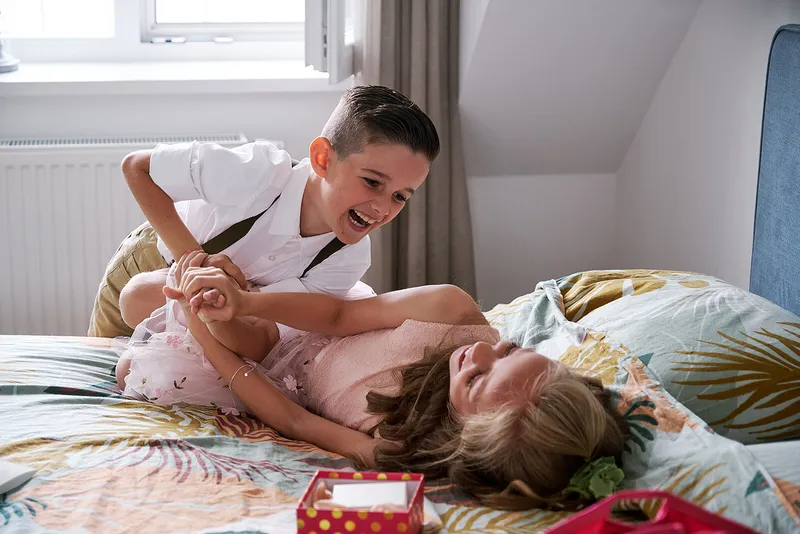De zoon en dochter van Romana en Sander stoeien op het bed