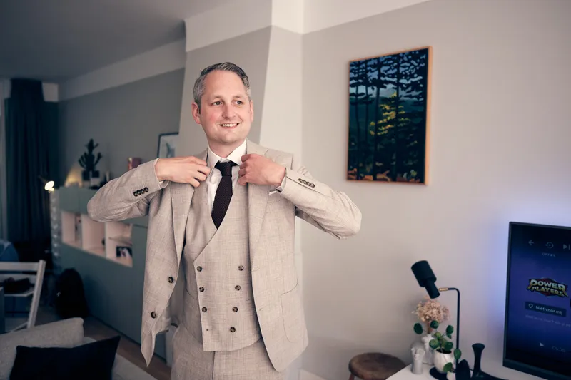 Krijn strikt zijn stropdas in de woonkamer