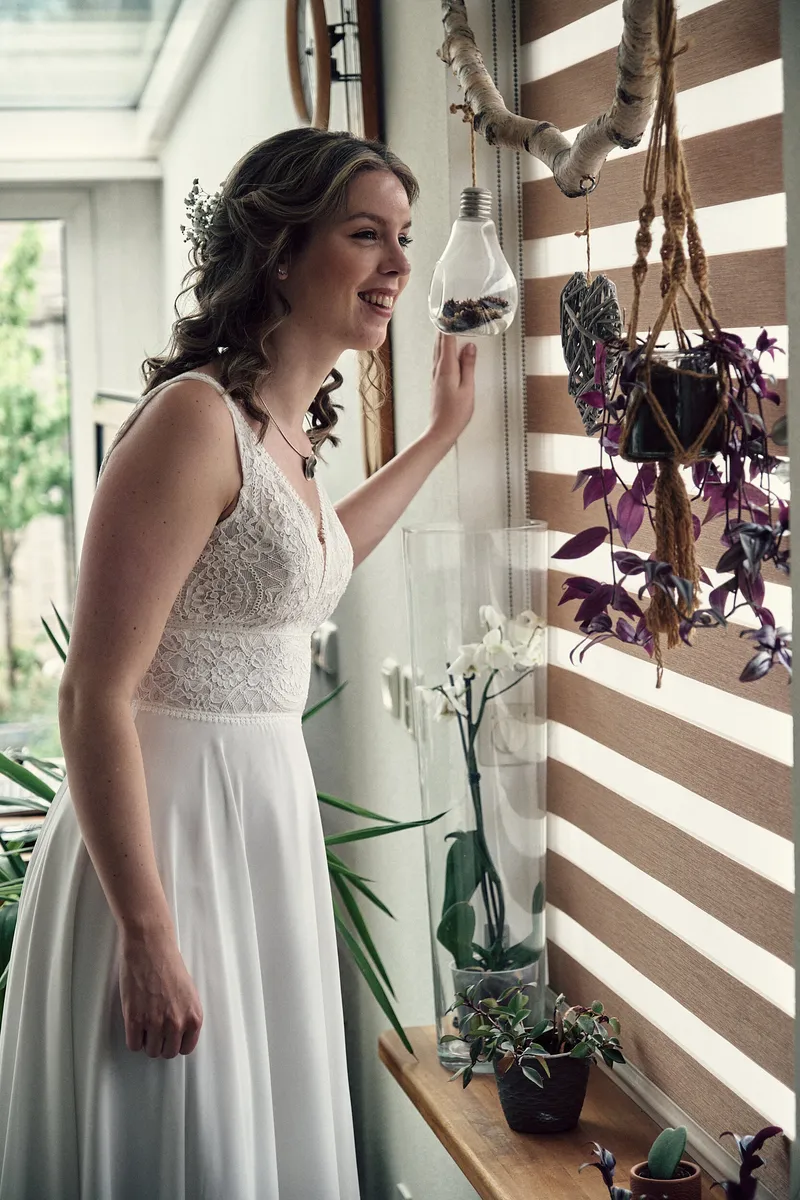 Renske in haar trouwjurk bij het raam
