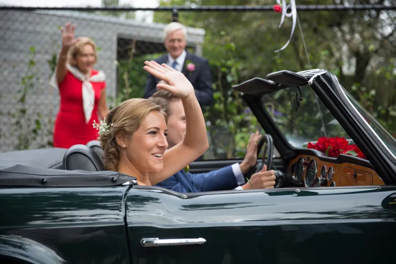 Karin zwaait vanuit de groene cabrio