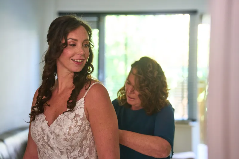Michelle lacht terwijl haar jurk wordt dichtgemaakt