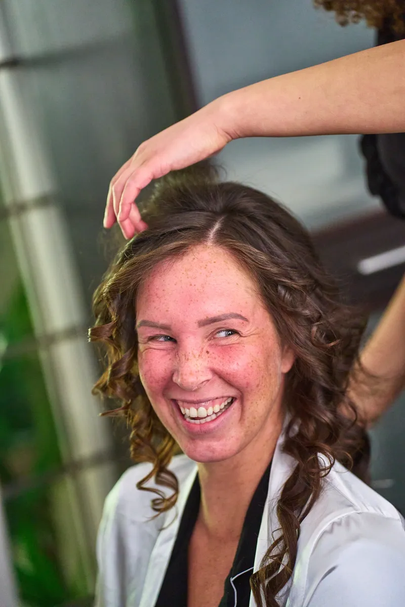 Close-up van Michelle die lacht terwijl haar haar wordt gedaan
