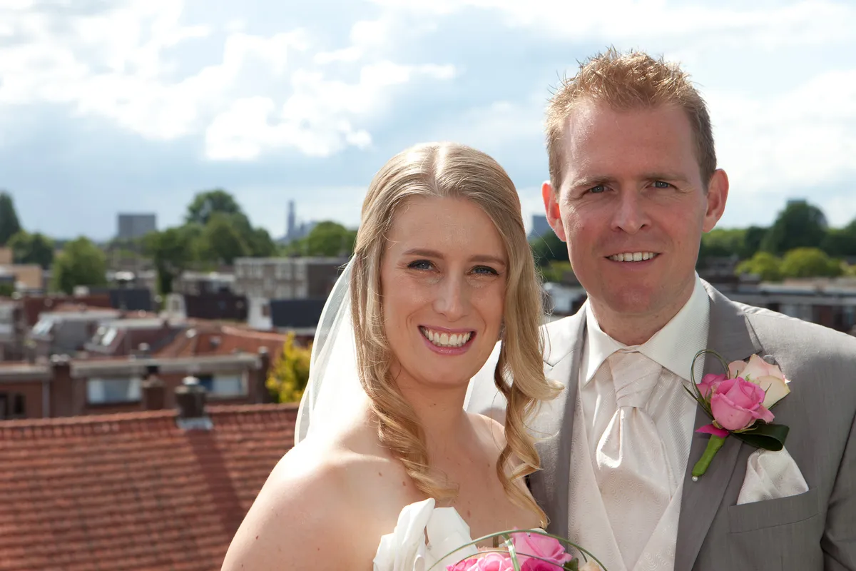 Loes en Jan lachen naar de camera, met de daken van Utrecht achter hen