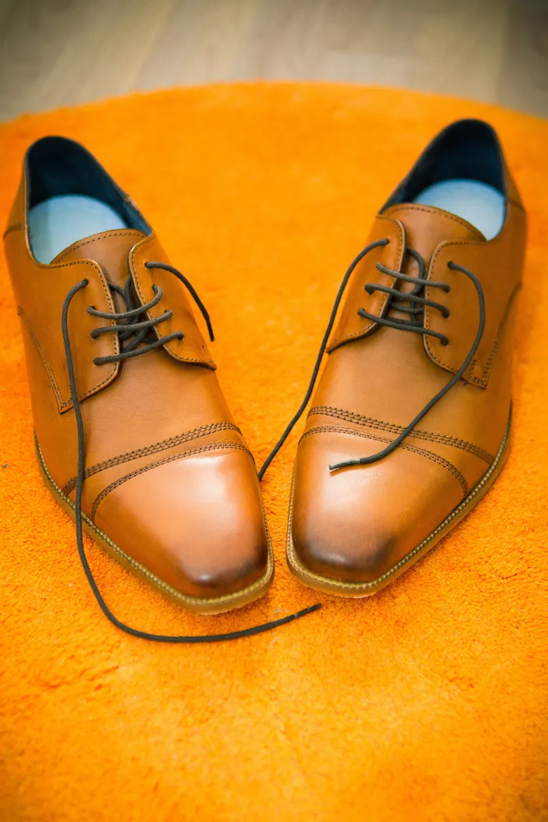 Bruine leren schoenen op een oranje kleed