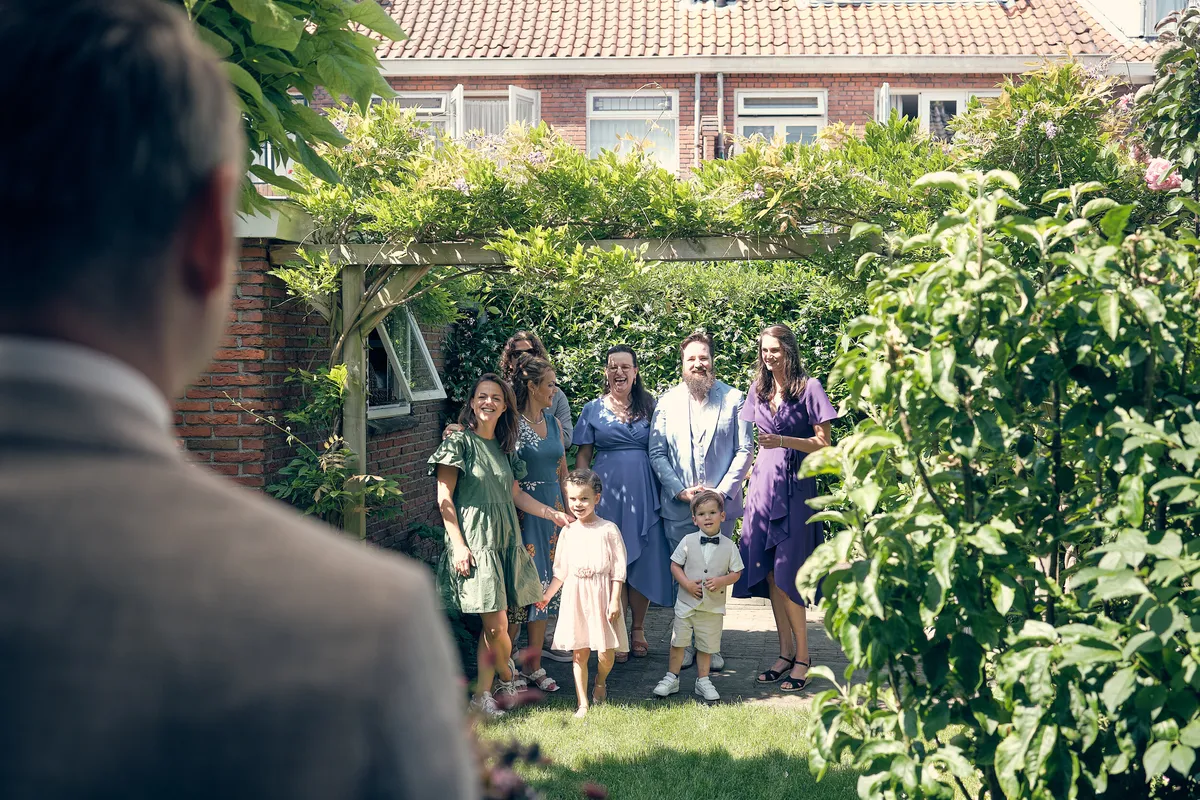 Krijn wacht in de tuin op de first look, familie en kinderen kijken toe