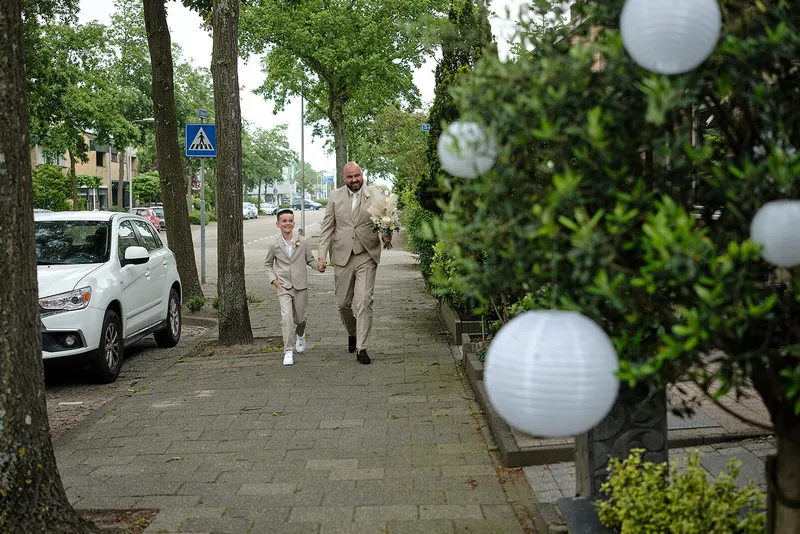 Michael loopt in zijn lichte pak door de straat, langs witte lampionnen