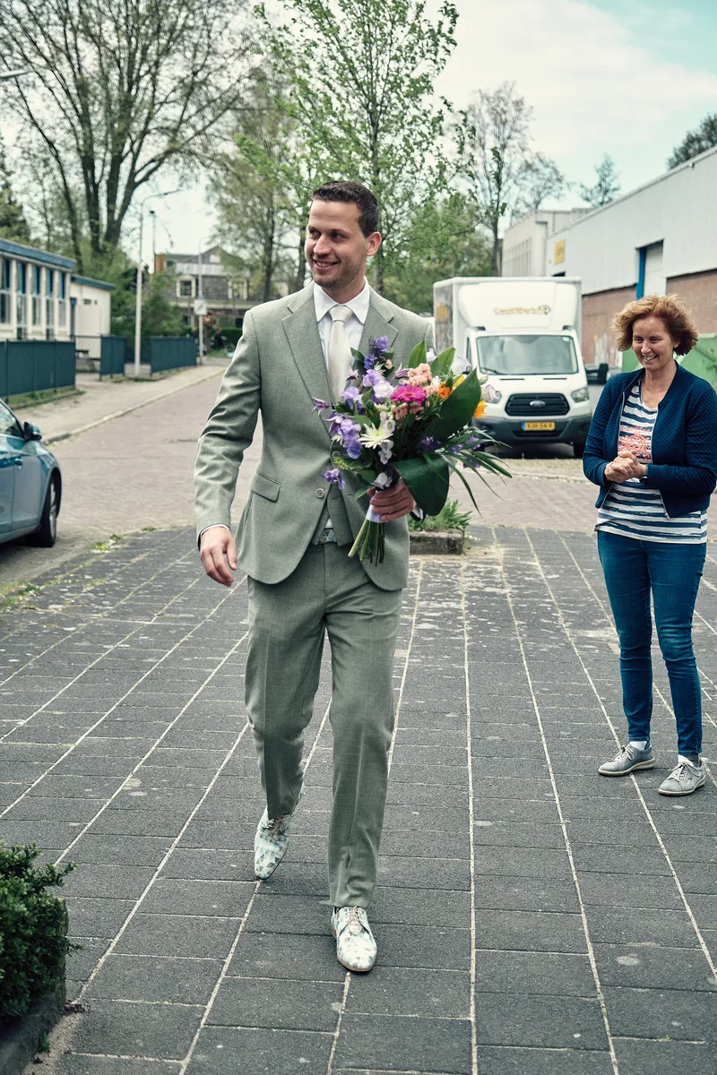 Tijmen loopt met het boeket door de straat naar Renske