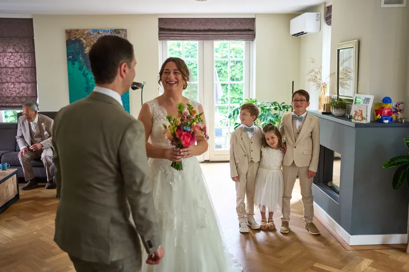 Caroline met het boeket, de kinderen kijken toe