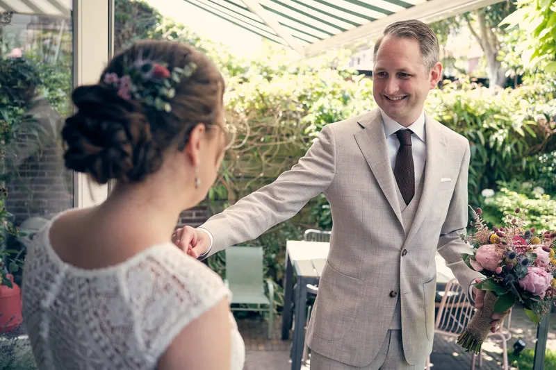 Krijn ziet Evelien voor het eerst in haar trouwjurk, in de achtertuin
