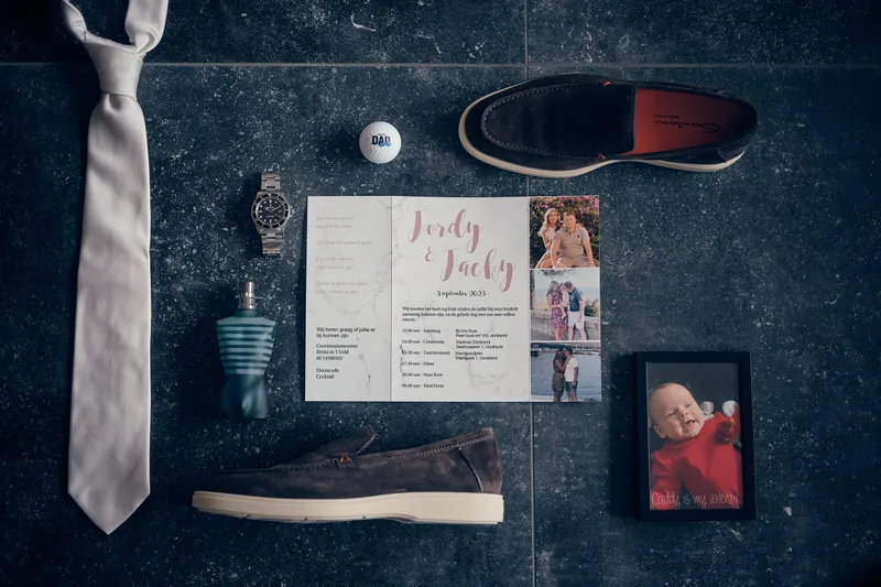 De das, schoenen, uitnodiging en een foto van het bruidspaar