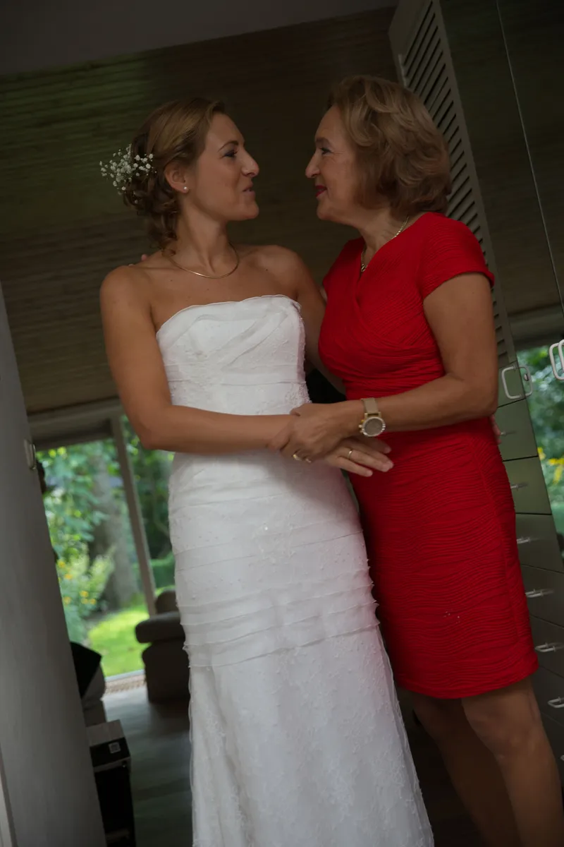 Karin in haar jurk, met een vrouw in een rode jurk