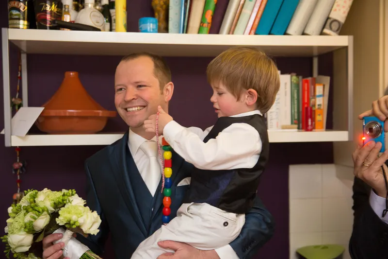 Maarten met zijn zoon op de arm, lachend