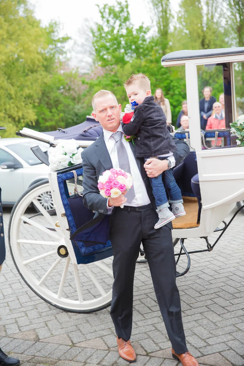 Sven met hun zoontje op de arm bij de koets