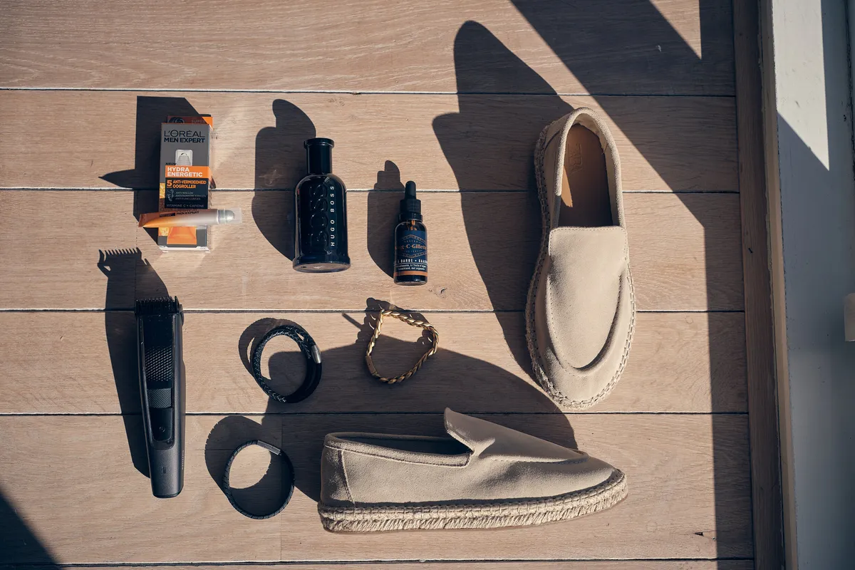 De schoenen, riem en verzorgingsspullen van Pascal op een houten vloer