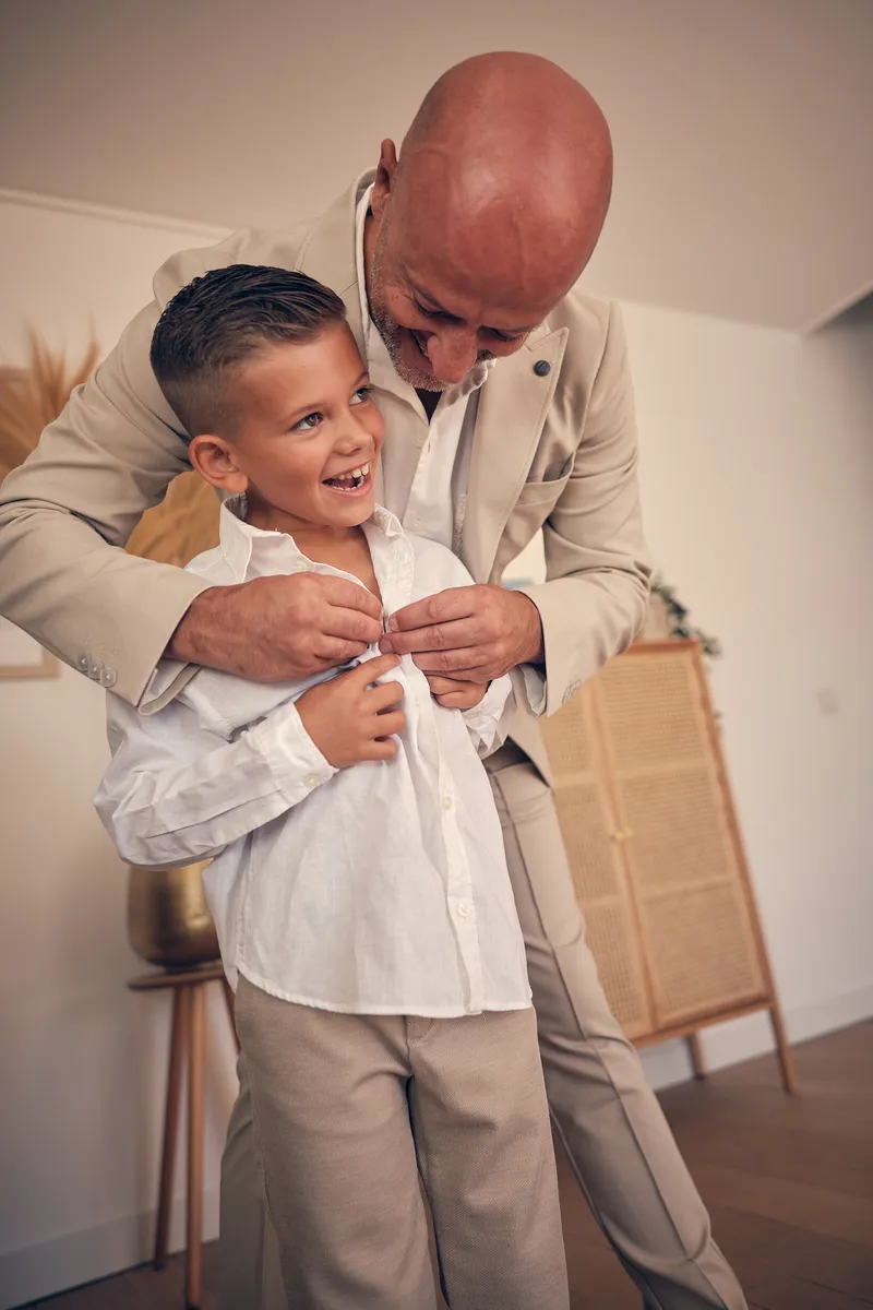 Pascal helpt zijn zoon met zijn overhemd