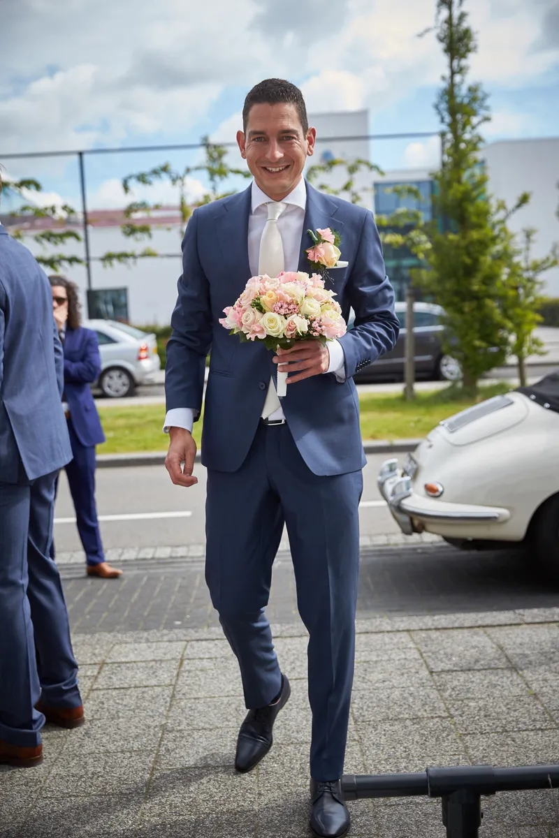 Patrick loopt met het boeket naar de deur