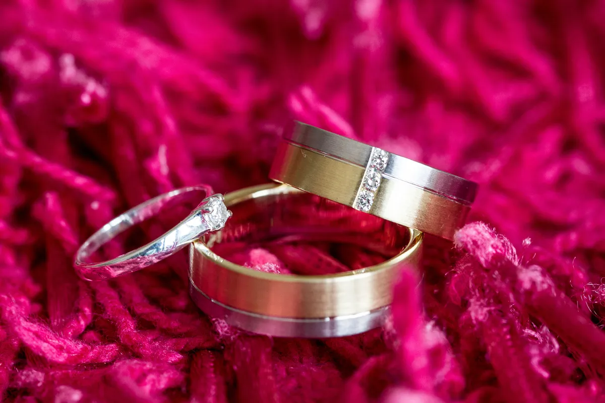 De trouwringen op een roze kleed