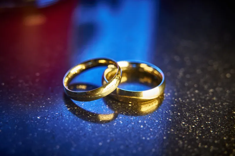 De gouden trouwringen op een glinsterende ondergrond