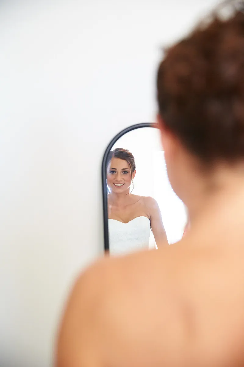 Sanne in haar jurk, van achteren, bij de spiegel