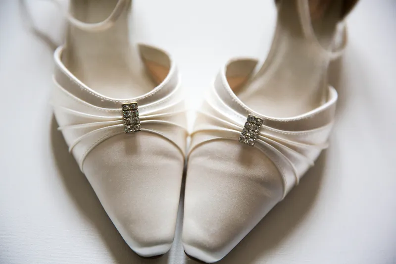 Witte trouwschoenen met een sierspeld