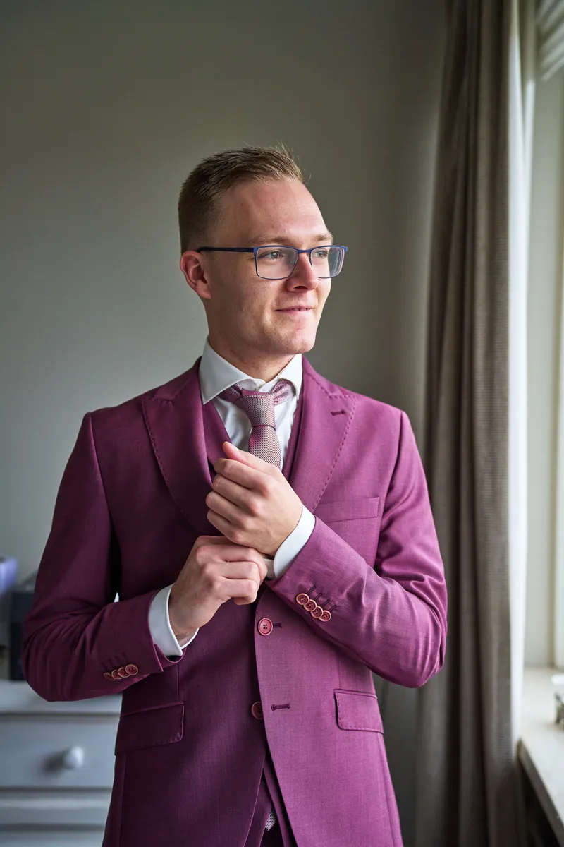Tom in zijn pak bij het raam