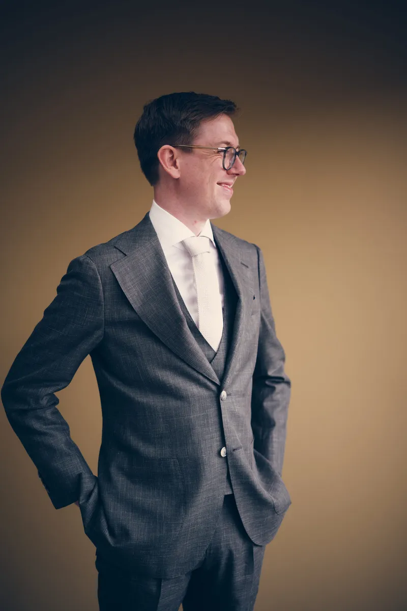 Yvo in zijn grijze driedelige pak, handen in de zakken