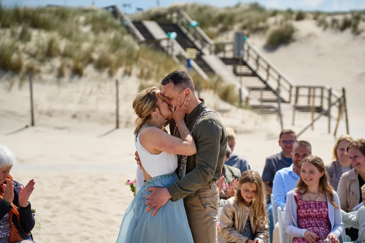 Elise en Erik kussen, met de trap en de duinen erachter