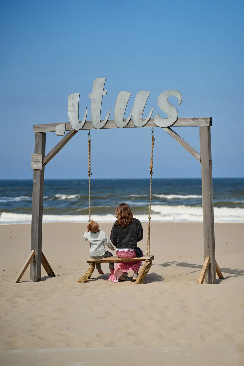 Een kind op de schommel van Titus aan zee