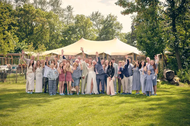 De groepsfoto met alle gasten voor de tent