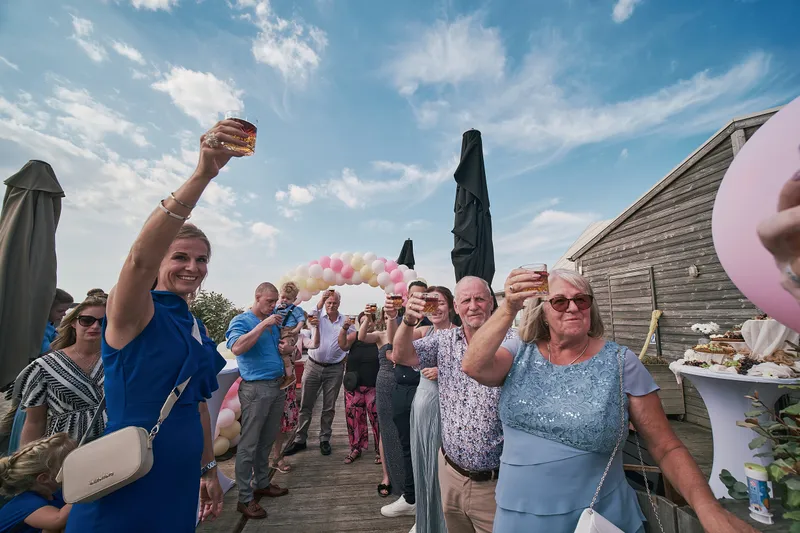 Gasten proosten op het terras van Brouw, tussen de roze ballonnen