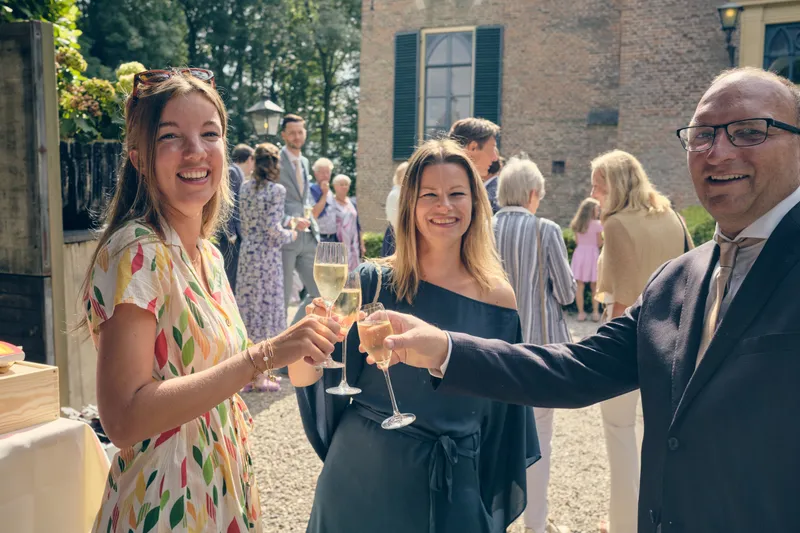 Gasten proosten met een glas bubbels op het voorplein