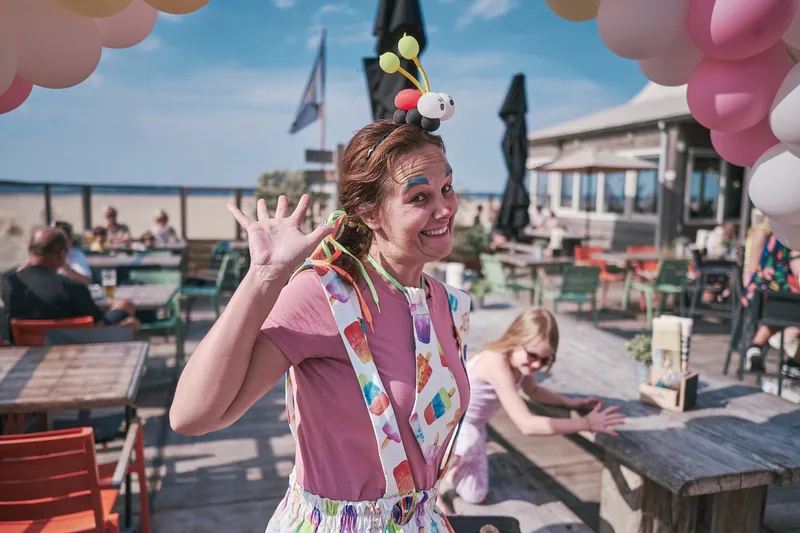 Clown Kim zwaait op het terras