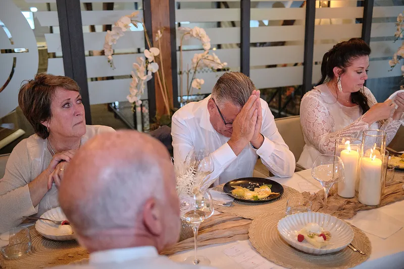 Een gast houdt zijn handen voor zijn gezicht tijdens een speech