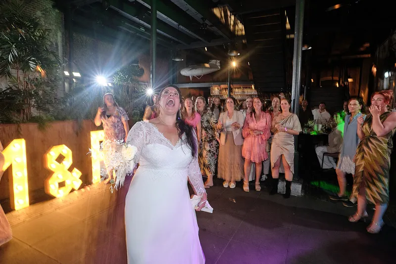 Regina staat klaar om het boeket te gooien, bij de lichtletters