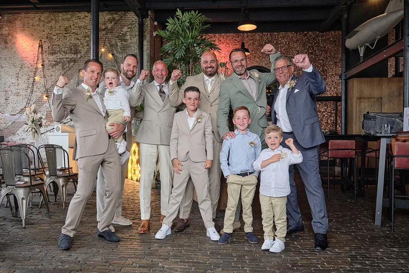 Michael juicht met de mannen en de jongens in lichte pakken