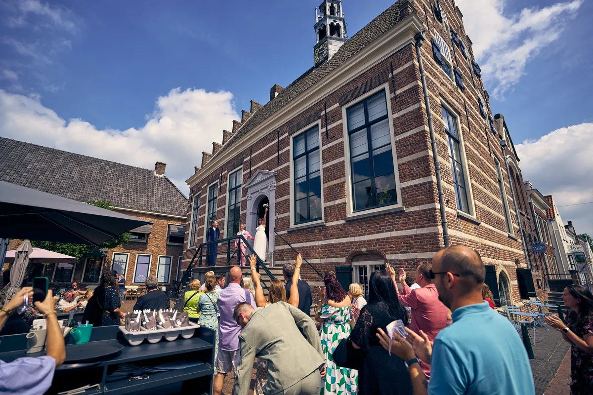 De gasten verzamelen zich voor het stadhuis van IJsselstein voor de groepsfoto