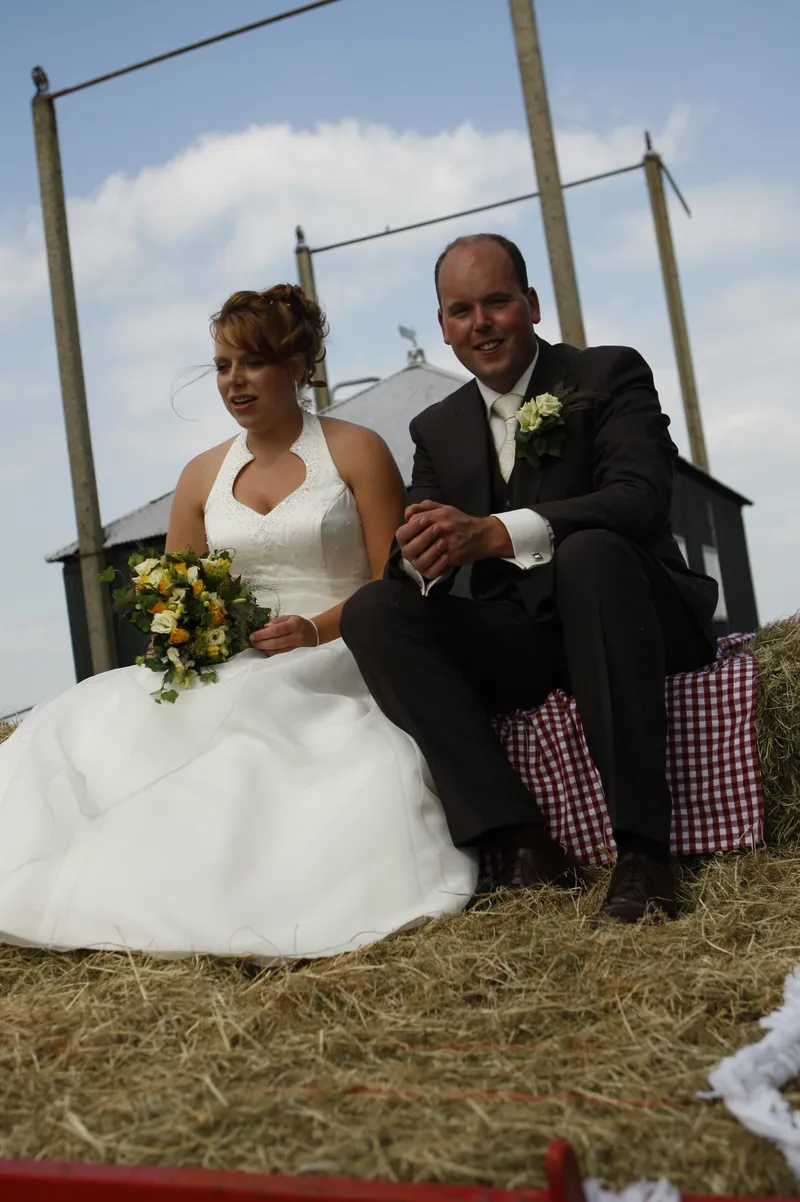 Yvonne en Robert-Jan zitten op de hooibalen op de aanhanger