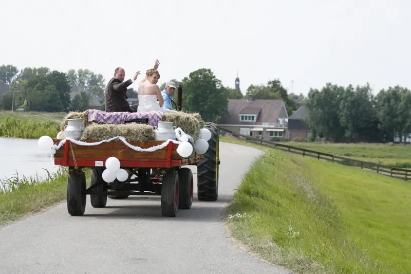 De trekker met de aanhanger rijdt over de dijk langs het water