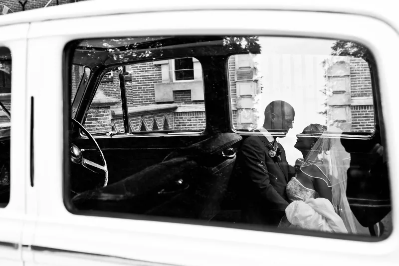 Zwart-wit: de bruid door het raam van de trouwauto