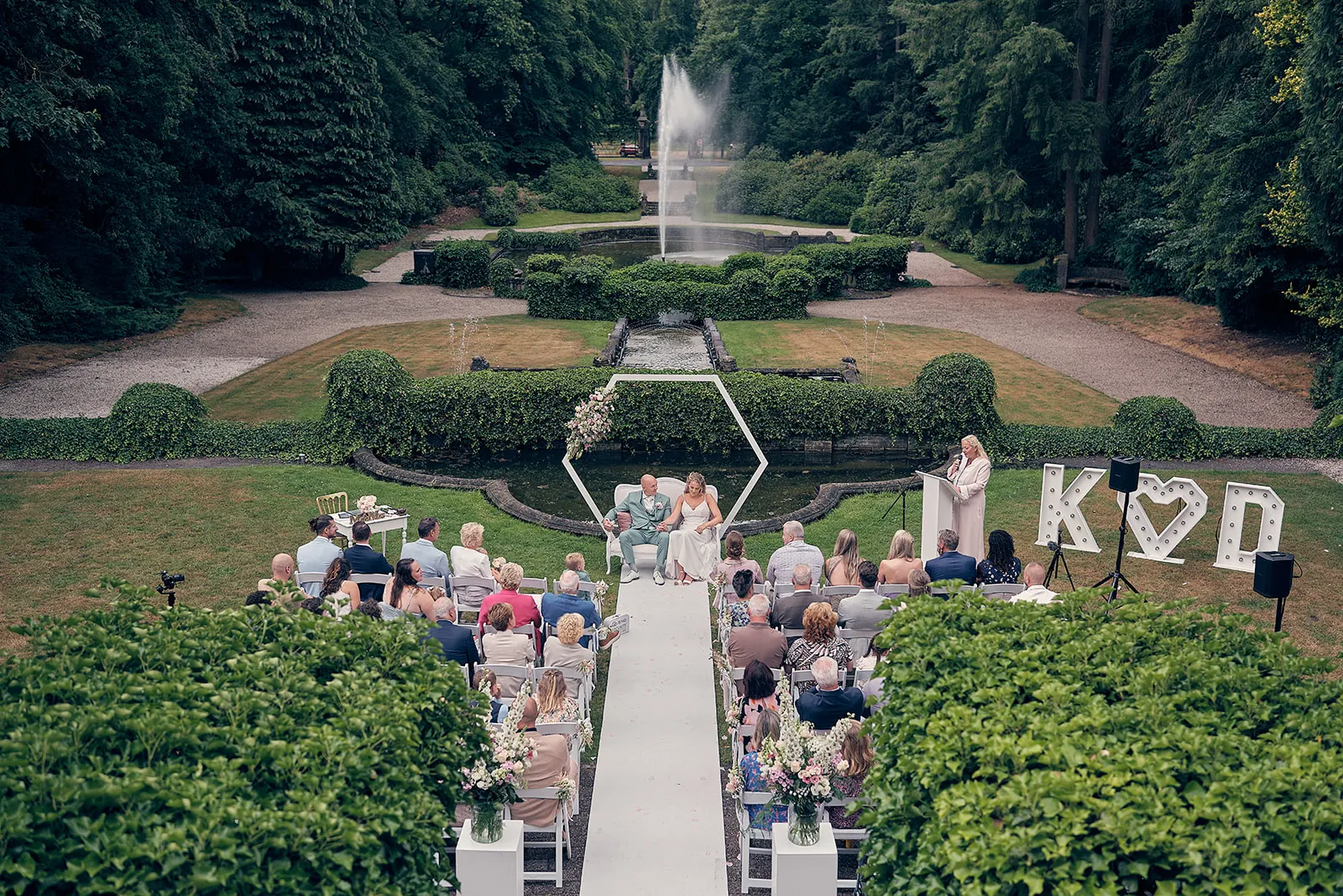 De ceremonie van Kim en Dennis in de tuin van Kasteel Hooge Vuursche, met de fontein in het midden