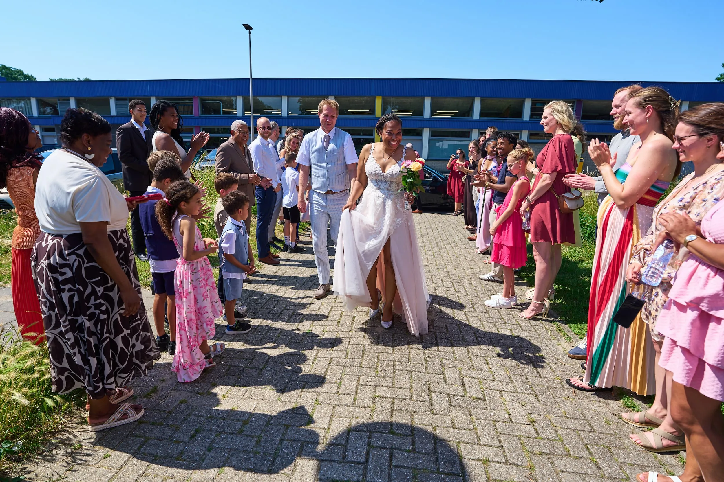 Bruidspaar loopt door erehaag van gasten bij trouwlocatie in Zoetermeer, bruidsfotografie — Trouwshoot Stefan Segers