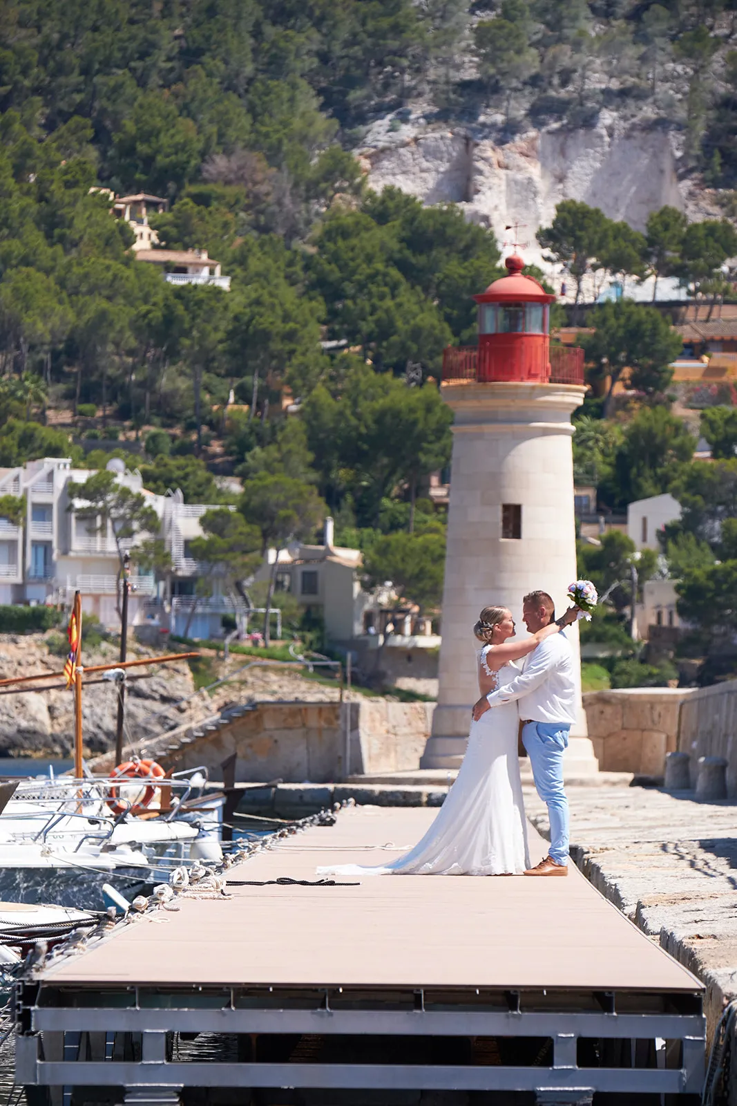 Bruidspaar Stephanie en Wesley op steiger Villa Italia Andratx Mallorca, vuurtoren achtergrond