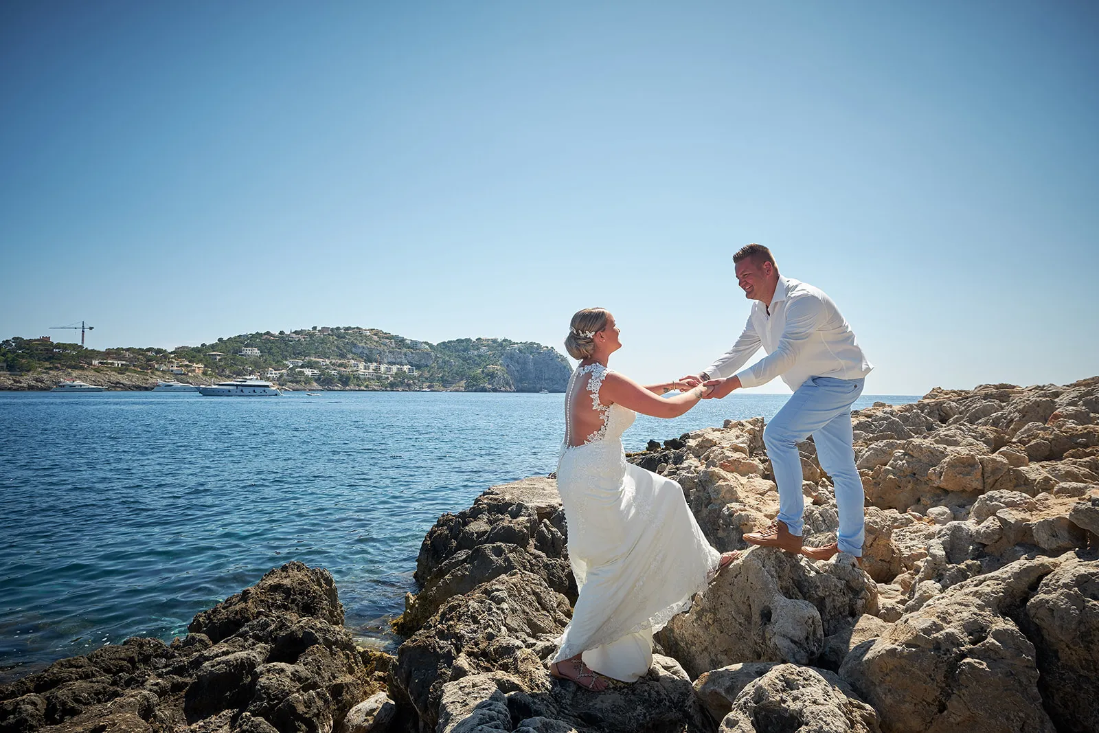 Bruidspaar Stephanie en Wesley dansen op rotsen bij strand Andratx Mallorca, trouwreportage Villa Italia