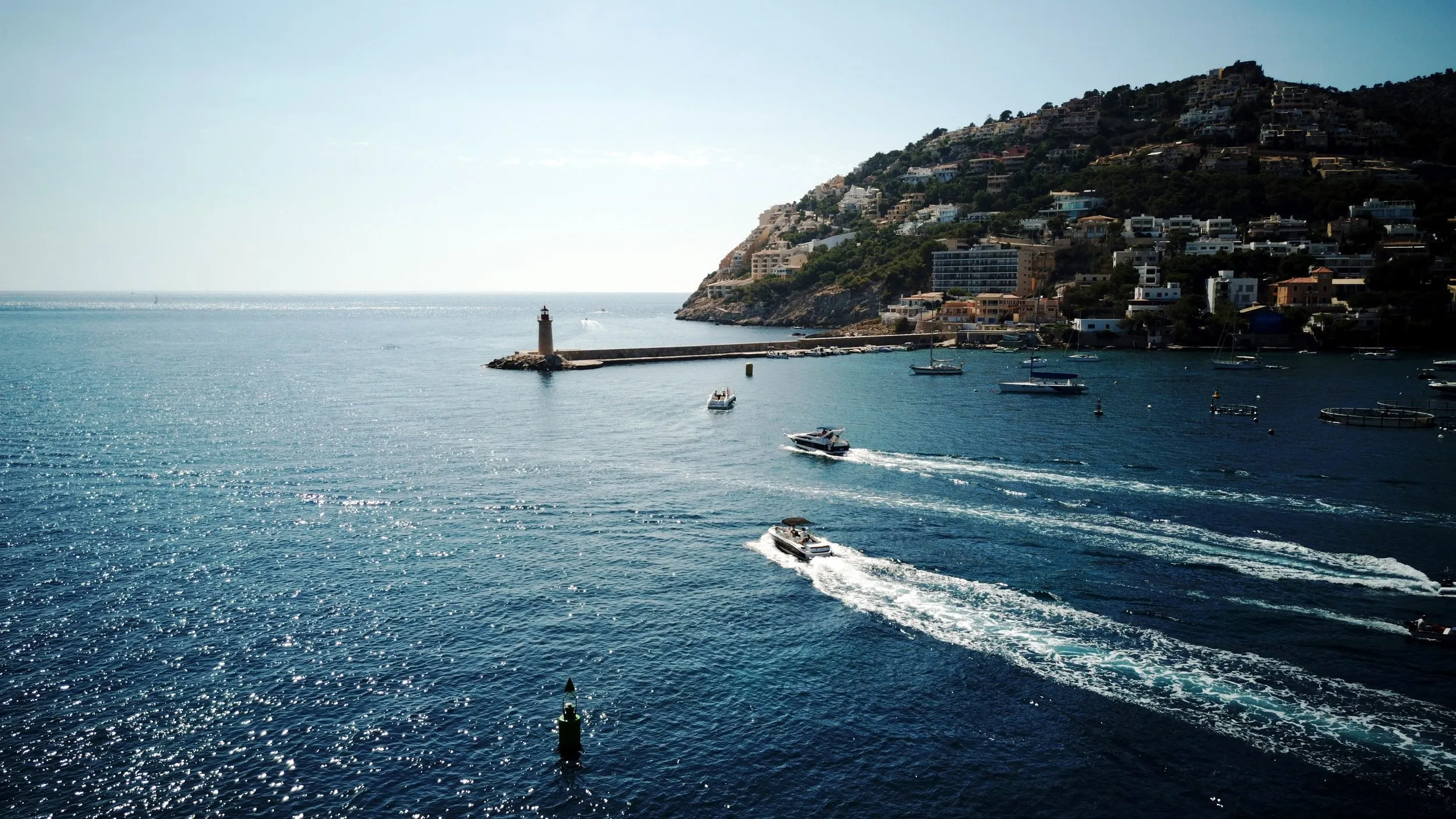 Idyllische baai met boten en steile heuvels onder mediterraan zonlicht