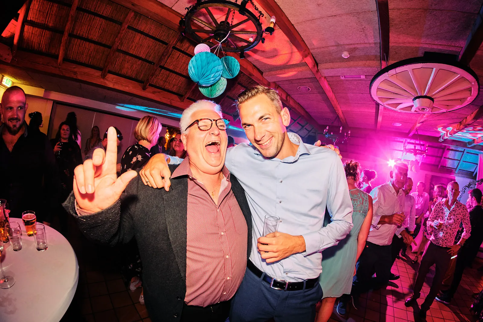 Bruidegom Patrick en gasten dansen uitgelaten op trouwfeest Ter Aard Delft, festive bruiloft sfeer met neonverlichting - Trou