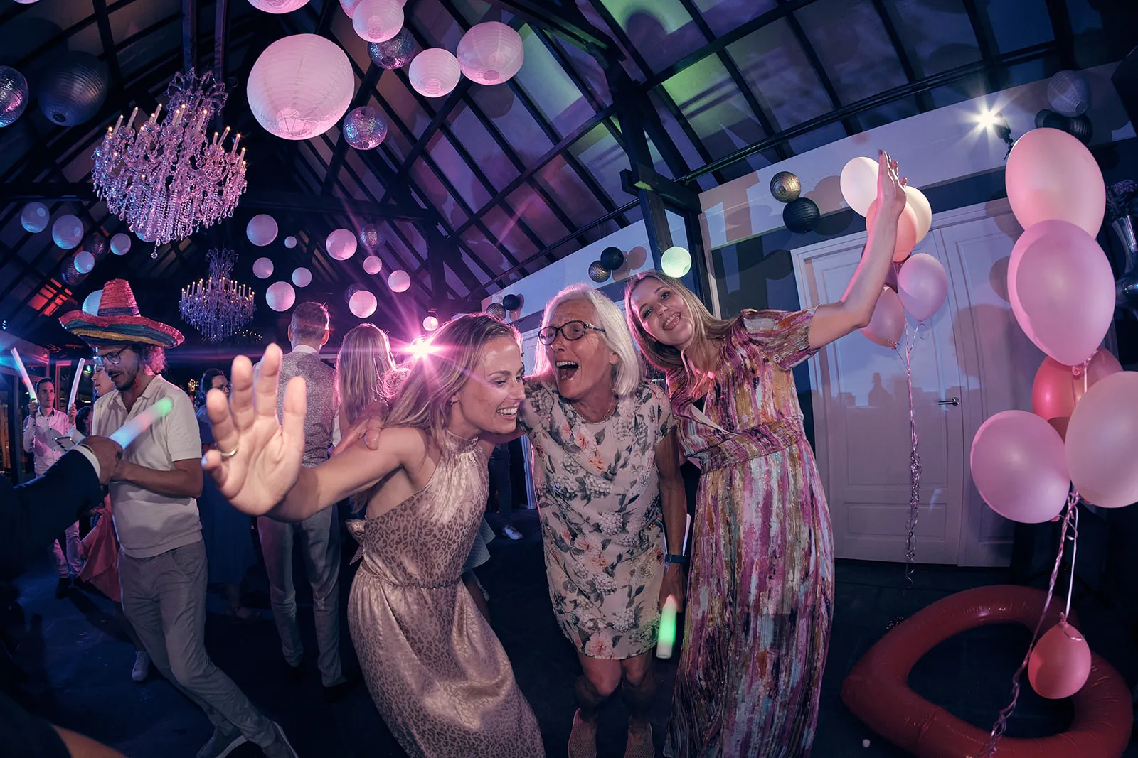 Bruidspaar Evelien en Krijn feest met gasten in feestzaal De Schaapskooi Delft, roze ballonnen en disco, trouwreportage - Tro